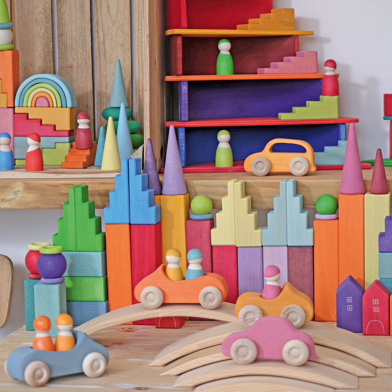 Display of grimms wooden toys showing rainbow, cars, and building blocks