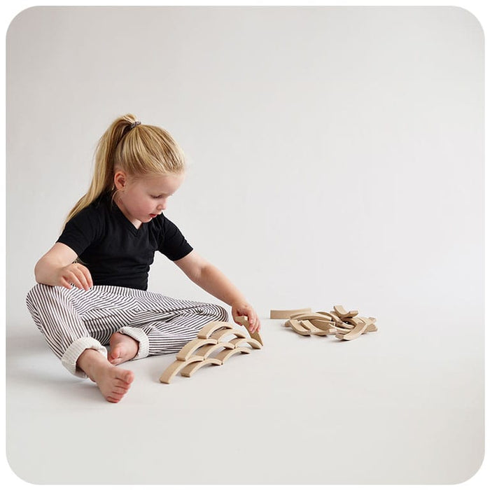 A child stacking Abel Blocks Mini 24 REWOOD in a shape similar to a pyramid