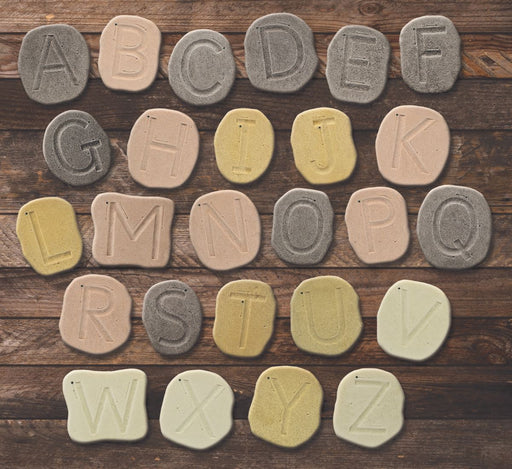 Tactile stones that have uppercase letters carved on them to trace on