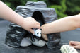Play Cave Made From Stone with a toy panda and some pebbles